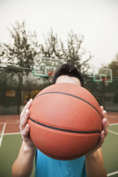 Mladý muž s basketbal na košíkovou — Stock fotografie