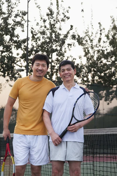 Vader en volwassen zoon tennissen — Stockfoto