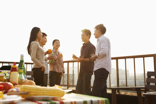 Grupo de amigos teniendo una barbacoa en una azotea — Foto de Stock