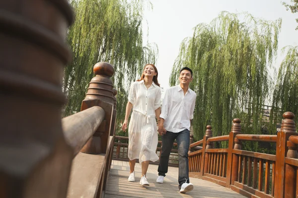 Junges Paar überquert eine Brücke — Stockfoto