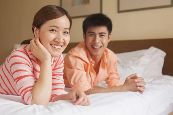 Junges Paar liegt auf Bett — Stockfoto