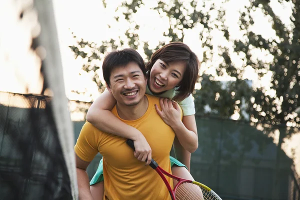 Couple into the tennis net — Stock Photo, Image