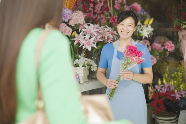 Kund som köper massa blommor i blomsteraffären — Stockfoto