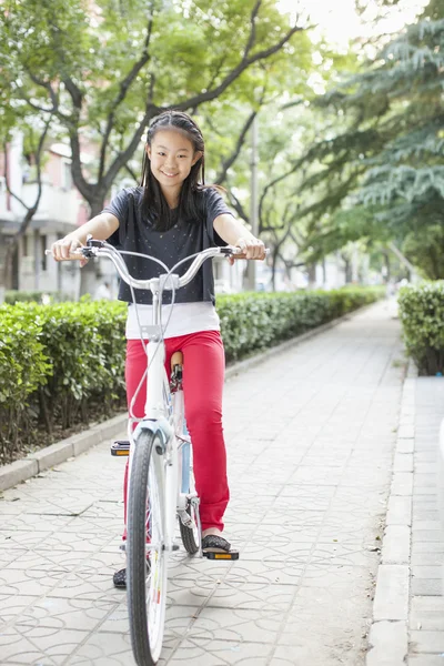 Joven chica montando su bicicleta —  Fotos de Stock