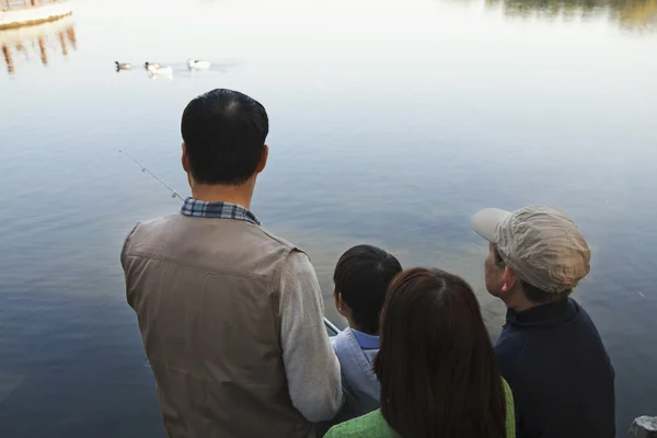 Family portrait with fishing gear at a lake — Stock Photo, Image