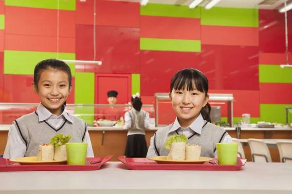 Duas meninas sentadas no refeitório da escola — Fotografia de Stock