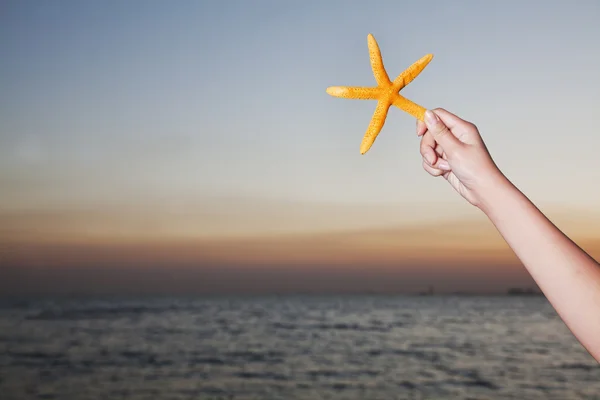 Adolescente menina segurando estrela do mar — Fotografia de Stock