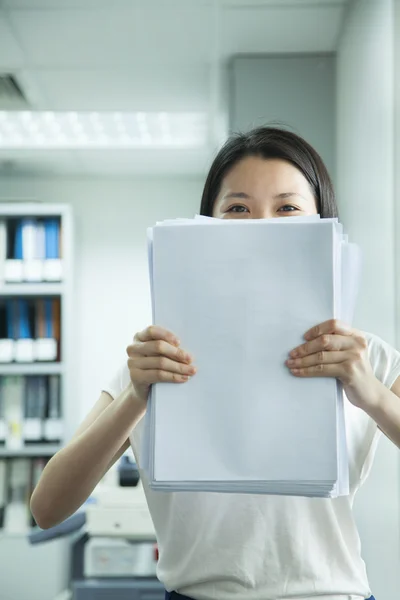 Empresária escondida atrás do papel — Fotografia de Stock