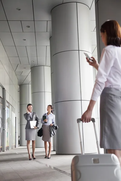 Drei junge Geschäftsfrauen gehen nach draußen und telefonieren — Stockfoto