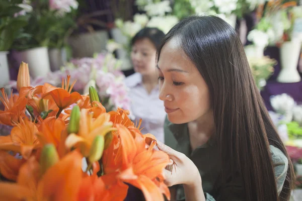 फूल की दुकान में फूलों को देख रही महिलाओं — स्टॉक फ़ोटो, इमेज