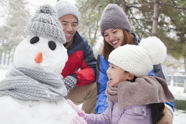 Familie sneeuwpop maken in de winter — Stockfoto