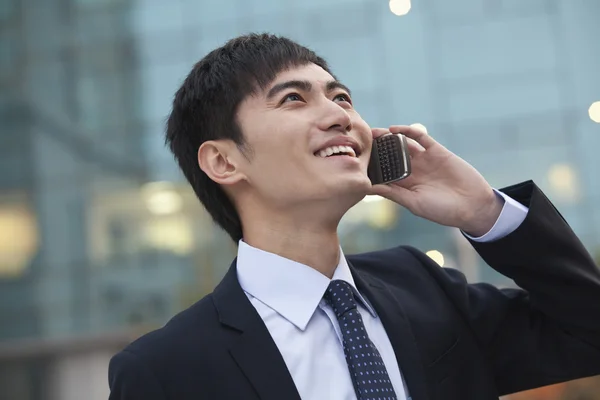 Empresario en el teléfono mirando hacia arriba — Foto de Stock