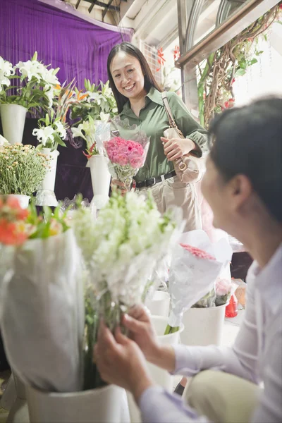 Cliente comprando um monte de flores na loja de flores — Fotografia de Stock