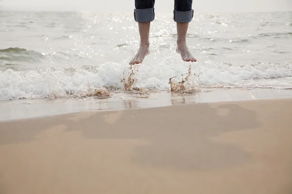 Joven saltando en las olas — Foto de Stock