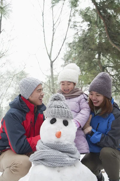 Familie sneeuwpop maken in de winter — Stockfoto