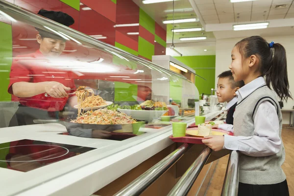 School children standing in line in school cafeteria — Stock Photo, Image