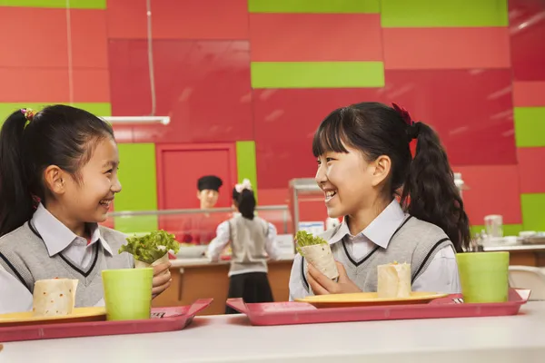 Due ragazze sedute nella mensa della scuola — Foto Stock