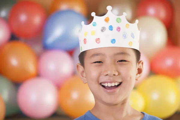 Birthday Boy vestindo uma coroa na frente de balões — Fotografia de Stock