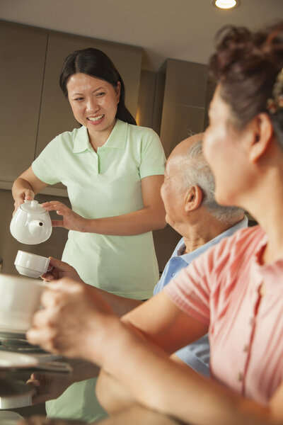 Parents with adult daughter having breakfast