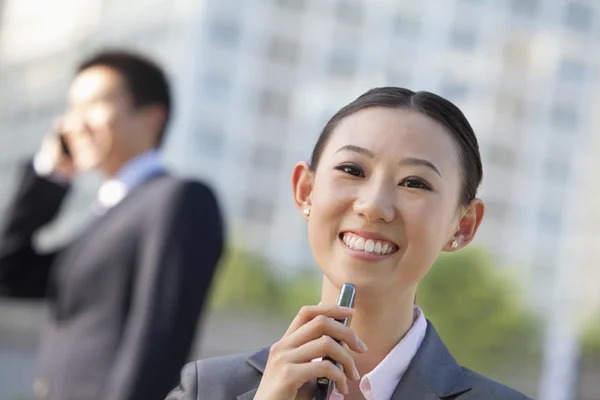 Two young business people holding phone — Stock Photo, Image