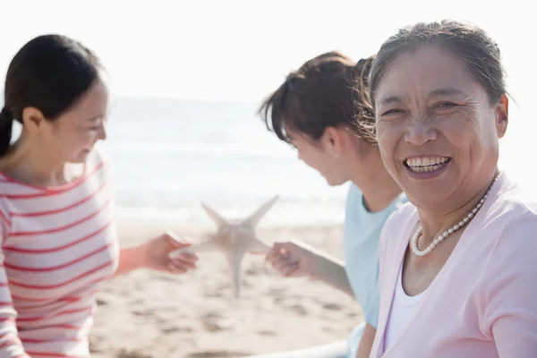 Familia en la playa, estrellas de mar —  Fotos de Stock