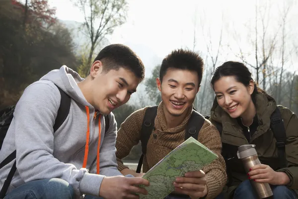 Friends sitting and looking at the map — Stock Photo, Image