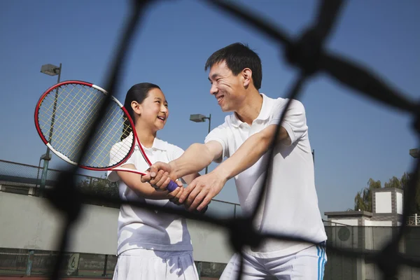 Ung flicka spela tennis med hennes tränare — Stockfoto