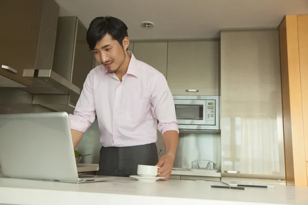 Geschäftsmann sitzt zu Hause vor seinem Computer und trinkt Kaffee — Stockfoto