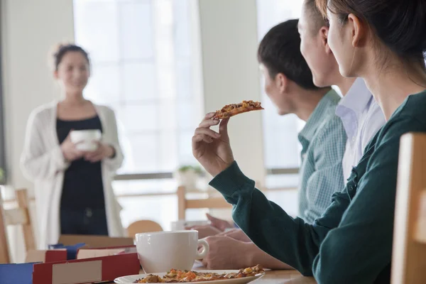 Mitarbeiter essen und arbeiten in der Cafeteria — Stockfoto