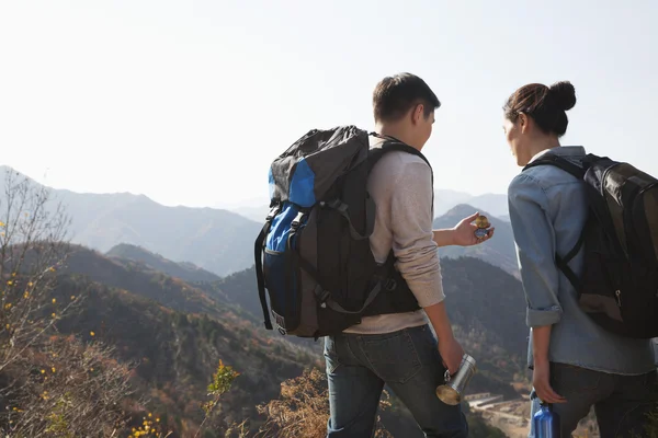 Couple hiking and looking at the compass — Stock Photo, Image