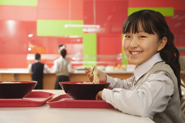 School girl eating noodles — Stock Photo, Image