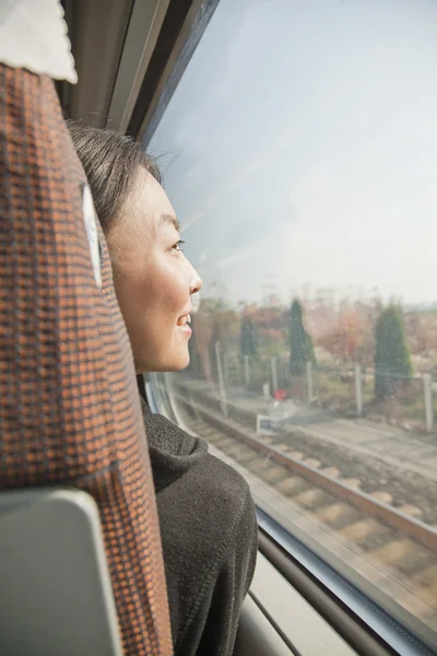 Mulher olhando pela janela de um trem — Fotografia de Stock