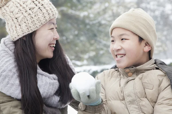 Mutter hilft Sohn beim Schneeball machen — Stockfoto