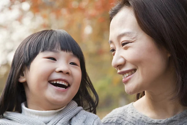 Mor och dotter leende i parken — Stockfoto