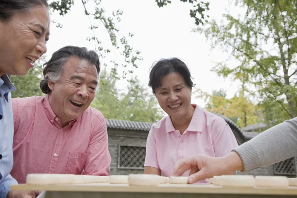 Mature people playing Chinese checkers — Stock Photo, Image