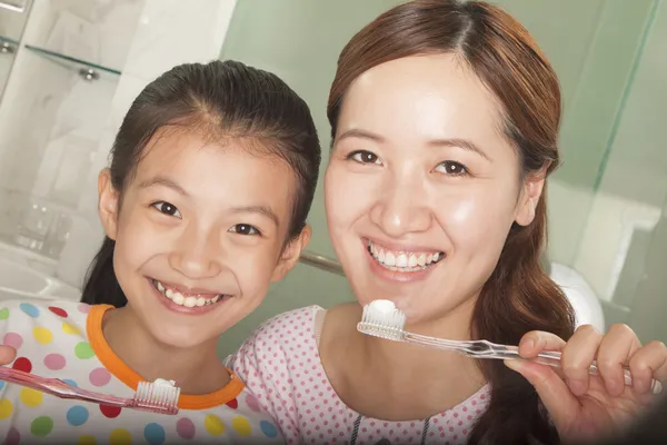 Mor och dotter borstar tänderna tillsammans — Stockfoto