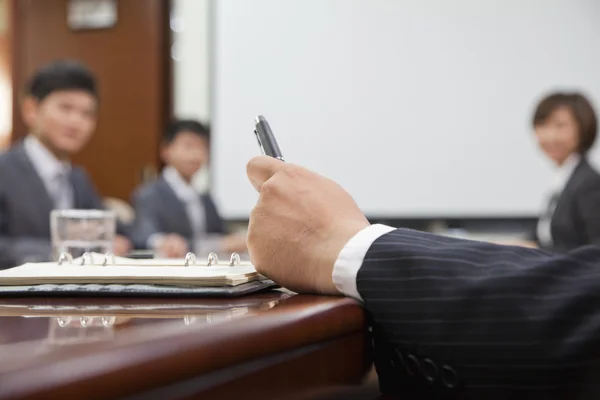 Mano de Empresario sosteniendo una pluma — Foto de Stock