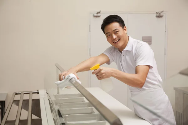 Cafeteria-Mitarbeiterin reinigt Essensausgabe-Bereich — Stockfoto