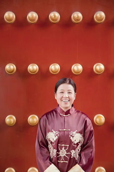 Женщина возле традиционной китайской двери — стоковое фото