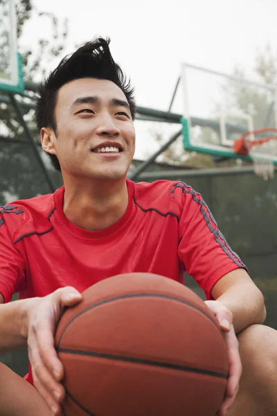 Jeune homme avec un ballon sur le terrain de basket — Photo