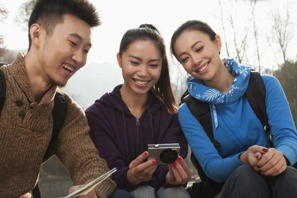 Amici che guardano la foto sulla fotocamera digitale — Foto Stock