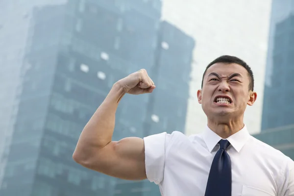 Jovem empresário flexão muscular — Fotografia de Stock