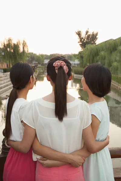 Drie vrienden kijken naar rivier — Stockfoto