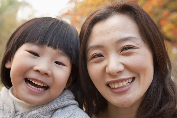 Mor och dotter leende i parken — Stockfoto