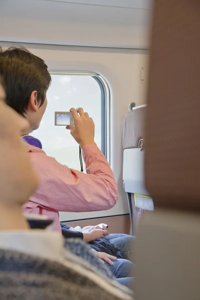 Homem tirando uma foto da janela do avião — Fotografia de Stock