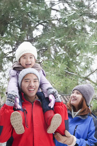 Father carrying daughter on shoulders in winter — Stock Photo, Image