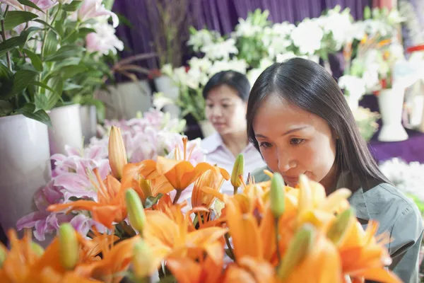 花屋で花を見て女性 — ストック写真