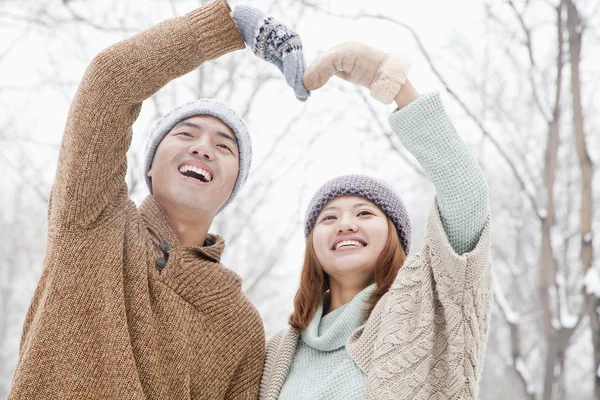 Casal fazendo forma de coração no inverno — Fotografia de Stock