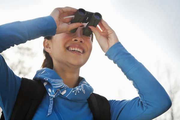 Mladá žena dívá dalekohledem — Stock fotografie