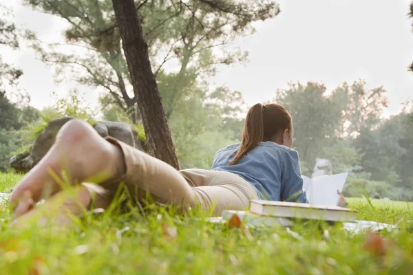 Девочка-подросток читает книгу в парке — стоковое фото